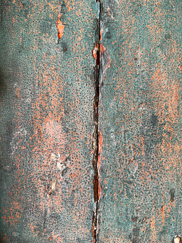 Stock photo showing close-up view of an old wooden door with weathered peeling blue paint.