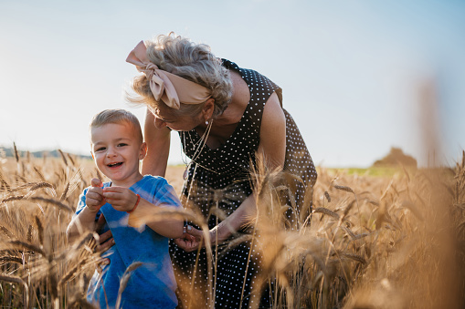 Grandma and her little grandson having happy moments in a field