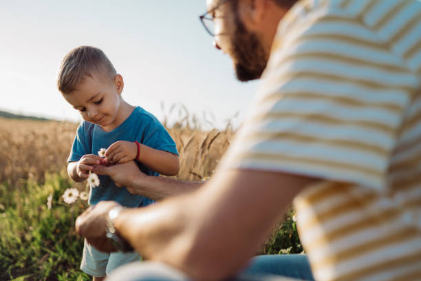 istock Handsome father and son smelling flowers 1578690709