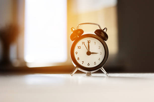 istock Modern black and white alarm clock in retro style isolated on white and grey background with shadow showing time three hours in afternoon. Siesta time, break, lunch concept. 1578737632