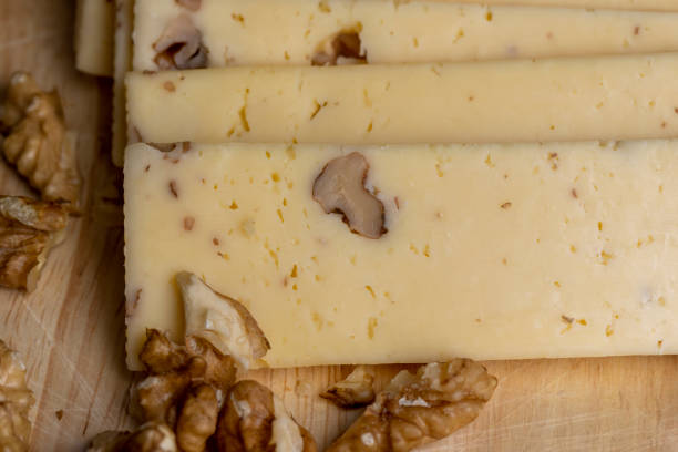 istock Sliced piece of milk cheese with walnuts 1578783194