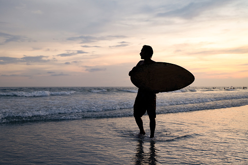 A teenager who is happy to surf by the sea