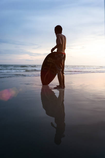 A teenager who is happy to surf by the sea