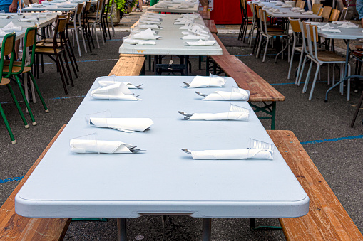 empty tables with cutlery waiting for food outside during a local holiday