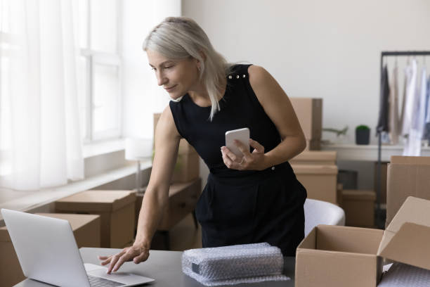 istock Busy entrepreneur woman using gadgets for processing Internet store order 1578912525