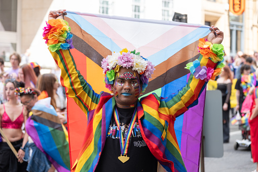 Liverpool, England - July 29, 2023: Person holding pride flag at Pride in Liverpool 2023 march