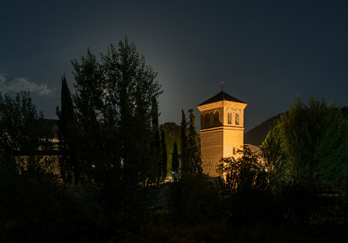 Tower of the church of the village of Yator, it is night and the light illuminates the tower, there are trees around, the sky is clear