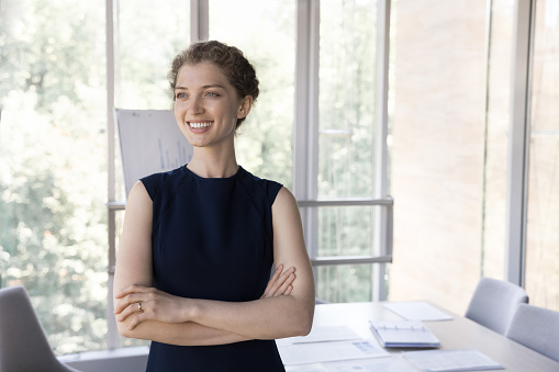 Happy business coach woman standing in office with whiteboard