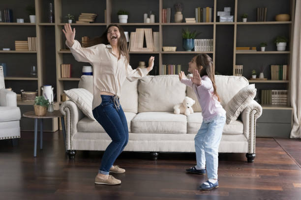 istock Excited happy dancer mom and kid dancing at home 1579067616