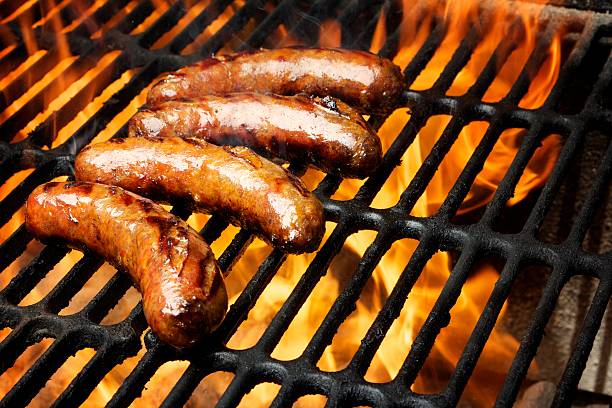 grelhador com a salsicha em - sausage bratwurst barbecue grill barbecue imagens e fotografias de stock