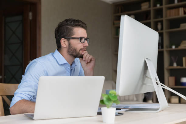 istock Serious busy young freelancer man working on online project 1579155254