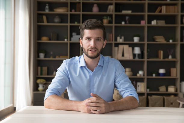istock Serious handsome young online teacher man giving webinar 1579155265