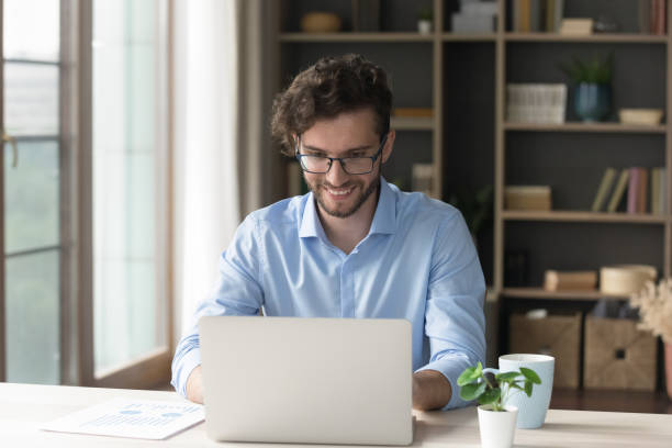 istock Positive handsome freelancer businessman in glasses working at home 1579155266