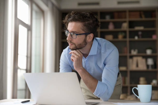 istock Thoughtful serious young small business owner man using Internet 1579168812