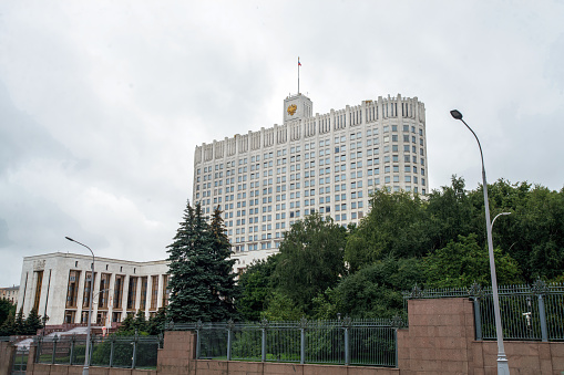 07-29-2023 Moscow Russia. Building of Russian government in cloudy summer with flag (not good looking). Park on territory