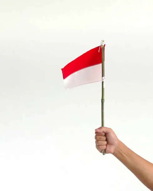 Photo of Hand holding a small Indonesia flag