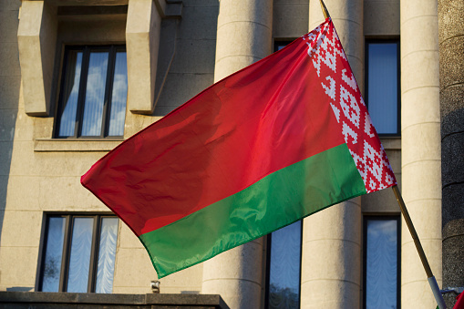 national flag of Belarus with the classic building background with columns
