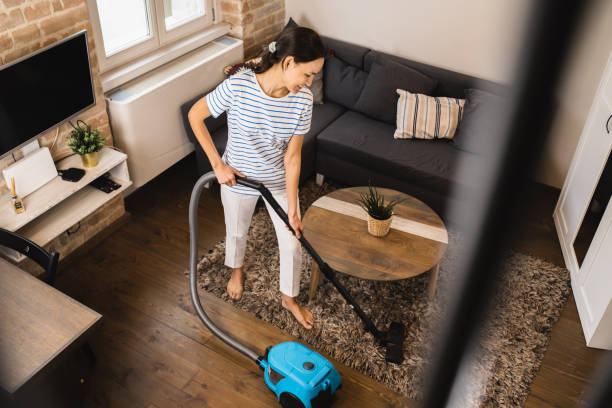 istock Woman cleaning her carpet with a vacuum cleaner 1579448556