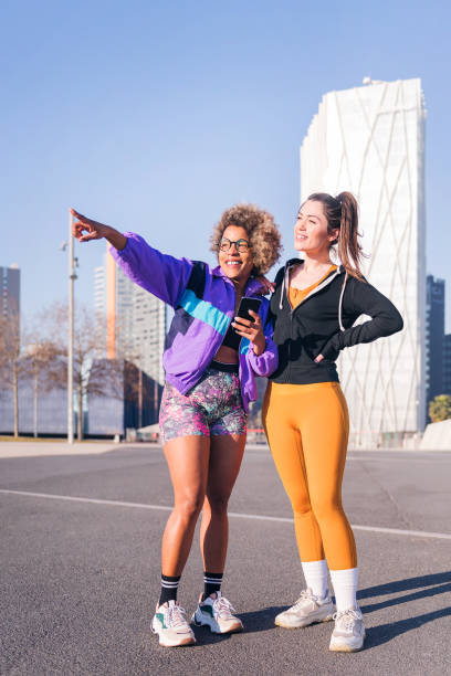 istock female runners pointing ahead standing in the city 1579456477