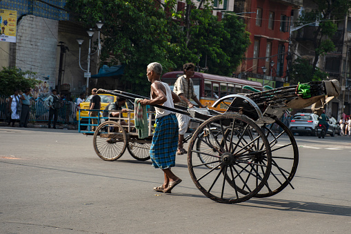 8th July, 2023, Kolkata, West Bengal, India: A old man pulling the famous hand pulled rickshaw of Kolkata.