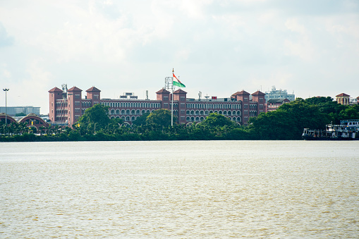 8th July, 2023, Kolkata, West Bengal, India: The famous Howrah Railway station on the bank of river Hooghly photo taken from other bank of river.