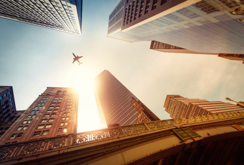 Skyscraper with a airplane silhouette in the sun, New York City