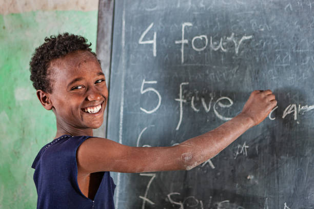 african little boy es el aprendizaje de inglés - education blackboard africa youth culture fotografías e imágenes de stock