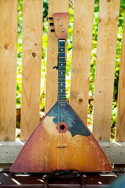 Russian balalaika a wooden fence background taken as clouse up.