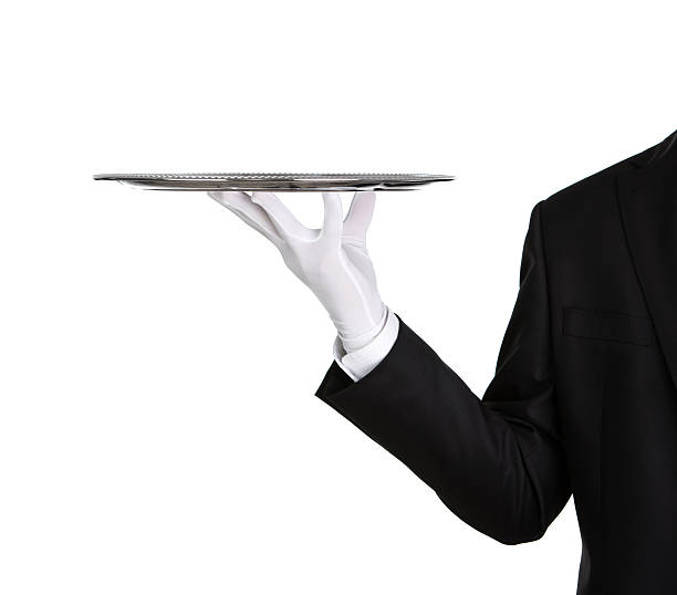 A waiter's arm holding an empty silver platter Waiter holding empty silver tray isolated on white background with copy space tray stock pictures, royalty-free photos & images