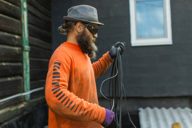 Beard man assembles the cable at the backyard.