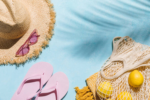 istock Summer flat lay with sunglasses, straw hat and beach accessories on blue background with palm leaf shadow, sun and sunlight. Vacation, holiday, summer creative concept, copy space, top view. 1579611621