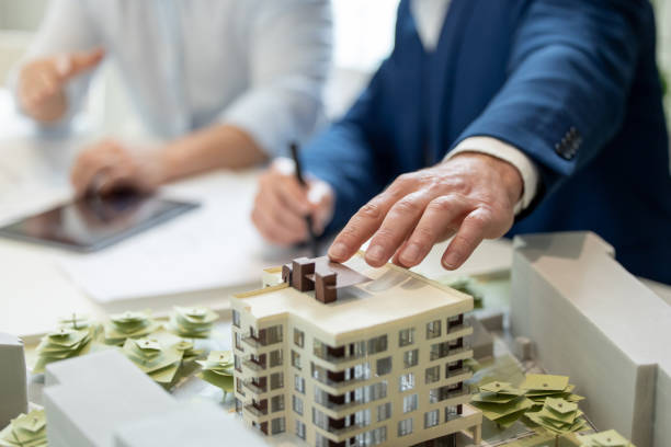 istock Male architect hands making model house, unrecognizable engineer working in the office. 1579616892