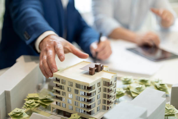 istock Male architect hands making model house, unrecognizable engineer working in the office. 1579616993