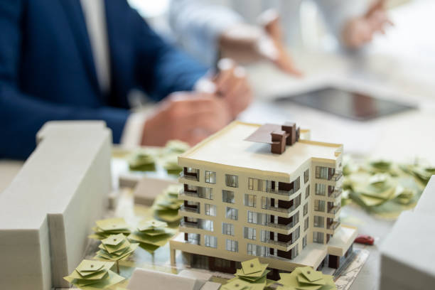 istock Male architect hands making model house, unrecognizable engineer working in the office. 1579616997