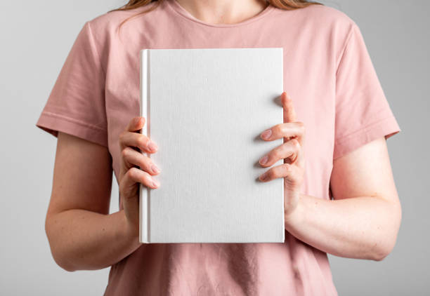 istock Hands holding book mockup, cover mock up 1579617587