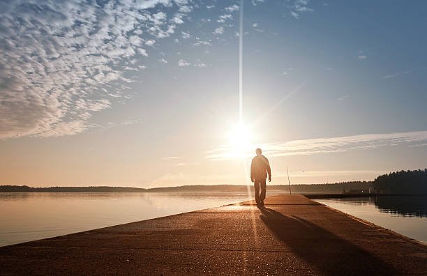 istock Man goes on the pier in sunrise 157962245