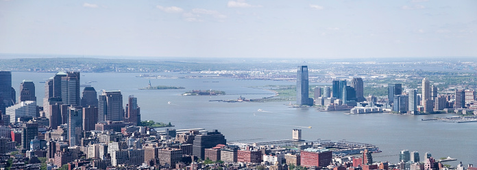 Panorama of the Hudson River, New York, in bird's view. You can see part of Manhattan (left), the Hudson River with Ellis Island and Liberty Island in the mid, New Jersey City with the Goldman Sachs Tower (right), and far away Staten Island. View from the Empire State Building.