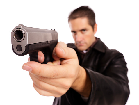 A man holding an abnormally enlarged handgun. Isolated on a white background and photographed with a wide-angle lens to distort the image and make the gun appear very large.