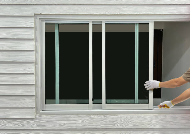 строитель ремонтирует раздвижное окно на искусственном деревянном сайдинге. - one way фотографии стоковые фото и изображения