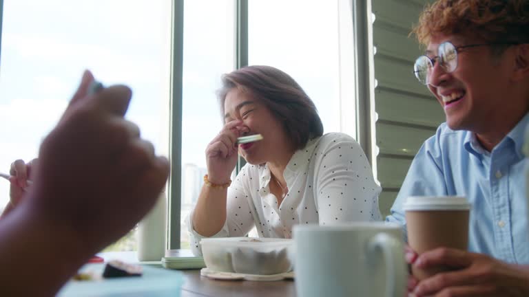 Senior white collar worker having fun talking and laughing during having lunch with colleagues.