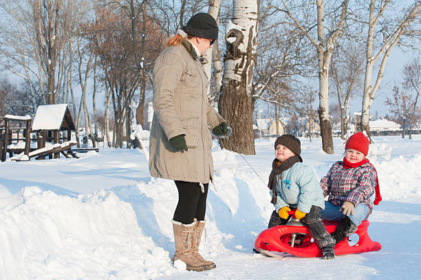 istock mother with children on snow 157977373
