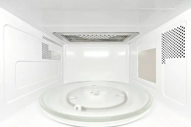 Frontal view inside white, empty clean microwave oven interior