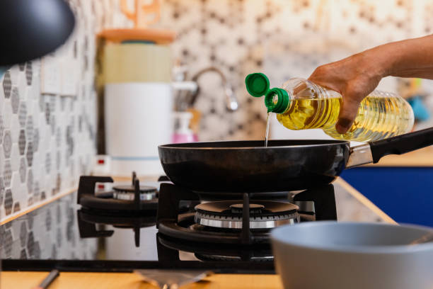 istock Senior cooking egg in kitchen using gas stove. 1579822071