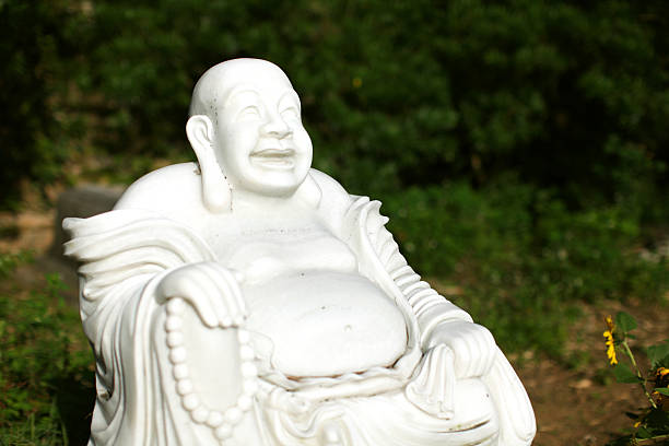 Buddha marble statue in zen garden Buddha marble statue sitting in the zen garden in Japan laughing buddha garden statue stock pictures, royalty-free photos & images