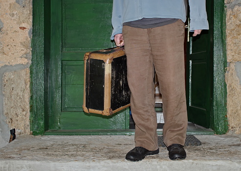 Man standing in the doorway with vintage suitcase
