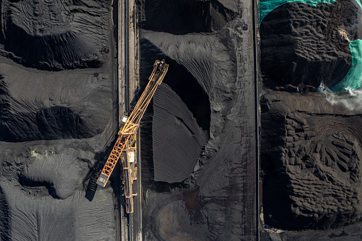The factory land full of coal is mechanically operating and transported