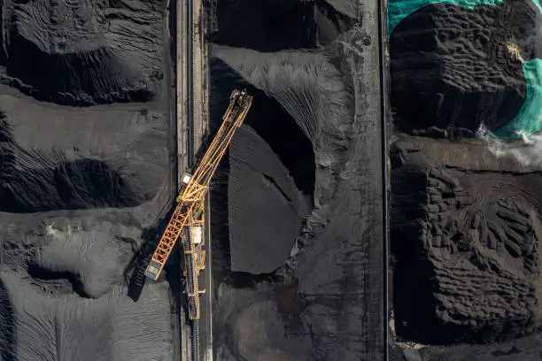 Photo of The factory land full of coal is mechanically operating and transported