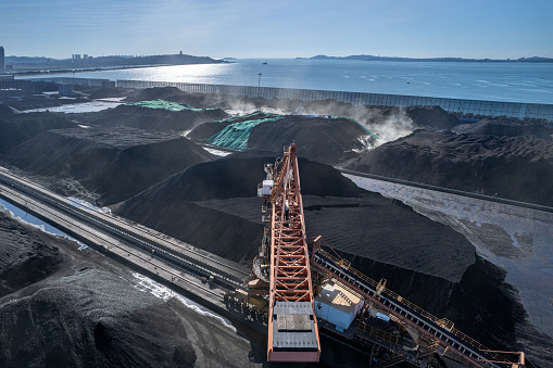 The port with coal is piled by the sea