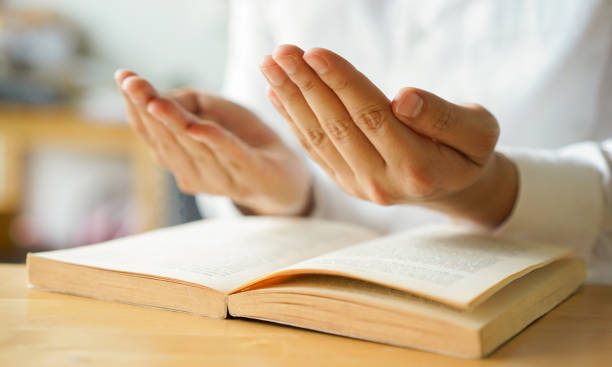 istock close up young man hand gesture to pray while reading holy book in home for ramadan tradition al and cultural of muslim religion concept 1579871184