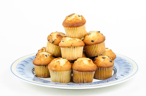Muffins with chocolate chips Pile of chocolate chip Muffins over decorated dish with white background madalena stock pictures, royalty-free photos & images